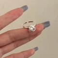 Close-up of a silver knot-shaped open ring showing intricate interwoven rope design detail - Open Knot / Silver