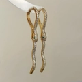 Detalle de pendientes de serpiente dorados con circonitas blancas y ojos de gema verde - Dorado