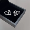 Nahaufnahme von silbernen Herzsteckern mit Zirkonia-Pavé in einer Samtschachtel - Silber vergoldete Zirkonia-Herz-Ohrringe