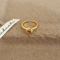 Close-up of golden knotted adjustable ring on rustic background with handmade ribbon - Gold