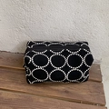 Schwarze Kosmetiktasche mit weißer Bestickung auf einer dunklen Holzbank - Groß / Schwarze Stickerei-Groß
