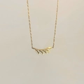 Detalle de collar de hoja dorada con textura mate y diseño de cadena fina elegante - Dorado