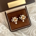 Dettaglio degli eleganti orecchini a grappolo di perle dorate con pietre di zirconi chiari - Oro