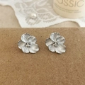 Makroaufnahme silberner Blumenohrstecker mit kleinen weißen Perlen und Kristallen - Silberne Blumenohrstecker