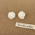 Détail macro de boucles d'oreilles roses en argent mat avec texture artisanale - Boucles d'oreilles clous camélia / Argenté