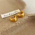 Macro shot of matte gold C-shaped earrings featuring colorful star-shaped zircon stones - Gold Color Brushed Stud Earring
