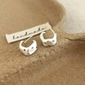 Macro shot of silver textured star-set earrings with colorful zircon on kraft paper - Silver Brushed Stud Earrings