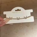 Dettaglio del bracciale a farfalla dorato con zirconi brillanti e catena regolabile in metallo - Oro