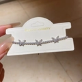 Dettaglio del bracciale tennis in argento con ciondoli a farfalla in zirconi scintillanti - Argento