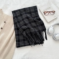 Winter black and white checkered plaid scarf with tassels in a cozy lifestyle setting - Black