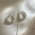 Dettaglio di orecchini a cerchio intrecciati argento con design a croce e chiusura a perno - Argento