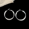 Macro detail of silver double-layered hoop earrings with textured shimmering finish - 3CM Diameter / Silver 3cm
