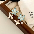 Detail of floral earrings featuring blue enamel petals and sparkling zircon accents - Blue Flower