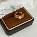 Detalle macro de anillo vintage dorado con diseño de coral y circonita ovalada - Dorado con circonita blanca