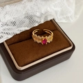 Detail eines Vintage-Goldrings mit ovalem rotem Edelstein und feiner Hohlwebung - Gold mit rosarotem Zirkonia