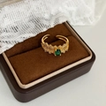 Detalle macro de anillo dorado ajustable con piedra ovalada verde y textura coral - Dorado con circonita verde
