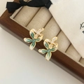 Détail macro de boucles d'oreilles fleurs en émail aux pétales dégradés sur bois - Dégradé Vert/Turquoise