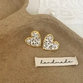 Detalle de pendientes de corazón huecos en oro y plata sobre bandeja hecha a mano - Bicolor Oro y Plata