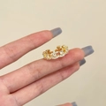Detailansicht Goldener Kronenring mit gewelltem Design und weißen Zirkonsteinen - Gold