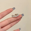 Nahaufnahme des silbernen Kronenrings mit Zirkonia an der Hand in warmer Umgebung - Silber