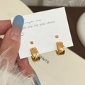 Dettaglio di orecchini a cerchio dorati con nodo intrecciato su cartoncino - Set di Orecchini d'Oro