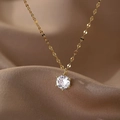Detalle de collar dorado con colgante de circonita cúbica redonda en engaste de seis garras - Collar de Oro