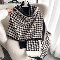 Classic houndstooth thick winter scarf with fringed edges displayed on a cozy white chair - Black and White Patchwork