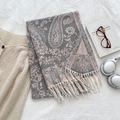 Grey and pink paisley shawl with white tassels styled with glasses and headphones - Gray