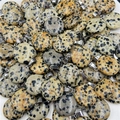 Detailed pile of natural spotted stone disc pendants with silver metal bails - Dalmatian Jasper