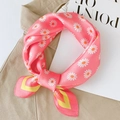 Gros plan d'un foulard en soie rose à motif marguerites noué sur un vêtement beige - Petite Marguerite Rose / 53*53cm