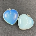 Macro detail of opal and milky white heart-shaped pendants with silver metal clasps - Opalite