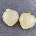 Macro view of two 30mm yellow crystal heart pendants with silver metal clasps - Topaz