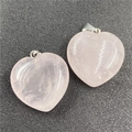 Macro detail of two heart-shaped rose quartz pendants with polished finish and silver bails - Rose Quartz