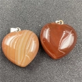 Detailed macro view of heart-shaped carnelian and striped agate gemstone pendants - Red Agate