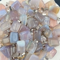 Macro view of various colorful rectangular natural stone pendants with silver clasps - Grey Agate