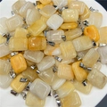 Macro shot of rectangular natural stone pendants with polished silver metal clasps - Topaz