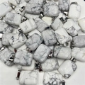 Macro view of rectangular white turquoise stone pendants with grey marble texture and silver bails - Howlite