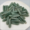 Close-up of green hexagonal crystal prisms with silver bails on a white tray - Green Aventurine