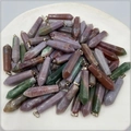 Close-up of assorted hexagonal natural stone pendants with silver metal clasps on a tray - India Agate