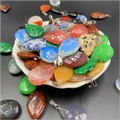 Primer plano detallado de colgantes de piedras preciosas talladas en un plato de concha - Colores Mezclados Aleatorios (1 Pieza)