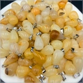 Bulk display of teardrop natural agate pendants with silver metal bails on a tray - Topaz