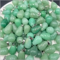 Vista macro di ciondoli a goccia in pietra verde con ganci argentati su vassoio - Avventurina Verde