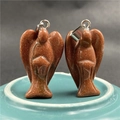 Detailed view of angel-shaped goldstone pendants with glittering finish and silver bail - Goldstone (Synthetic)