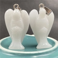 Close-up of two white natural crystal angel pendants with elegant silver metal bails - White Jade