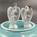 Detailed view of two clear crystal angel pendants with silver clasps on a blue base - White Crystal