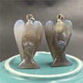 Close-up of dual angel-shaped natural agate pendants with abstract carved wing details - Grey Agate