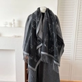 Thick charcoal cat jacquard scarf with fringe trim worn over a grey winter wool coat - Black
