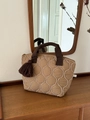 Borsa tote kaki trapuntata con manici marroni e cuciture a onde in ambiente domestico - Cachi