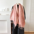Pink and beige plaid cashmere scarf with long tassels draped on a charcoal grey coat - Pink