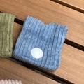 Hellblaues Cord-Armband zum Gesichtswaschen mit weißem Knopf auf Holzuntergrund - Cord Graublau
